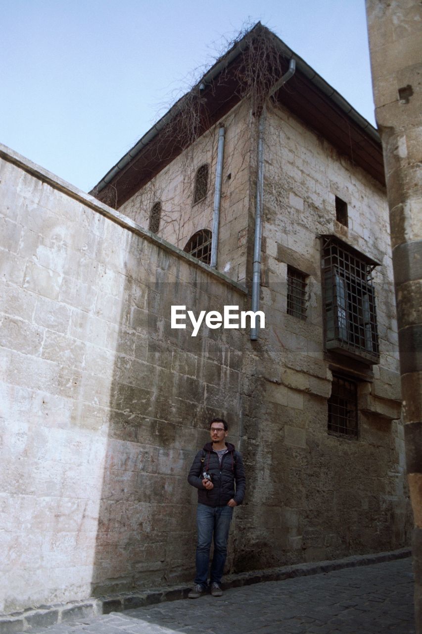 WOMAN STANDING IN FRONT OF BUILDING