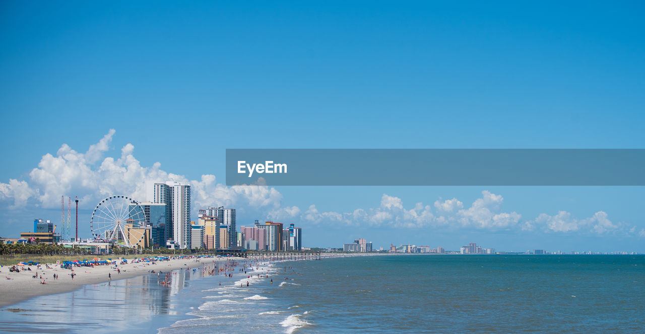 Panoramic view of sea and buildings against sky