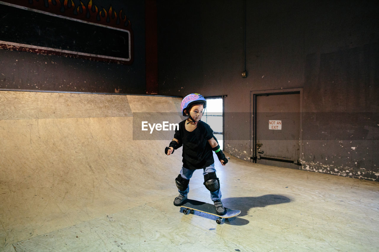 Focused skateboarding boy at an indoor skatepark