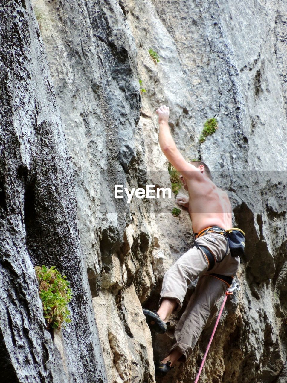 Low angle view climber rock climbing on mountain