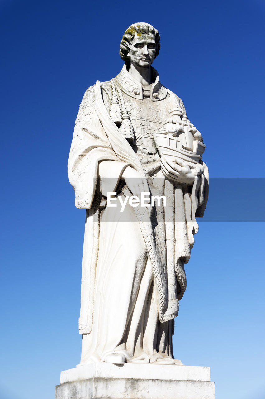 Low angle view of sao vicente statue against clear blue sky