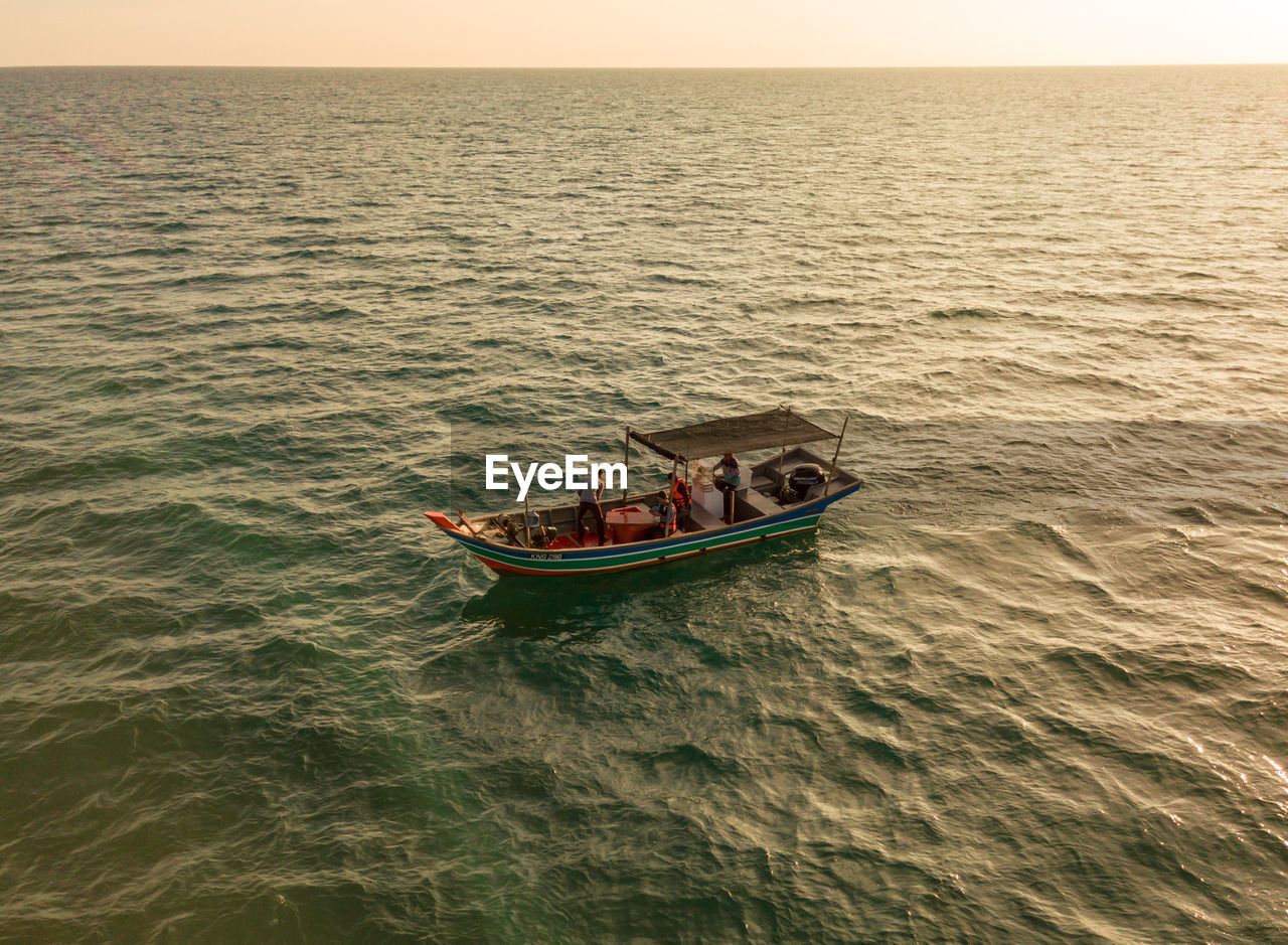 PEOPLE IN BOAT SAILING ON SEA