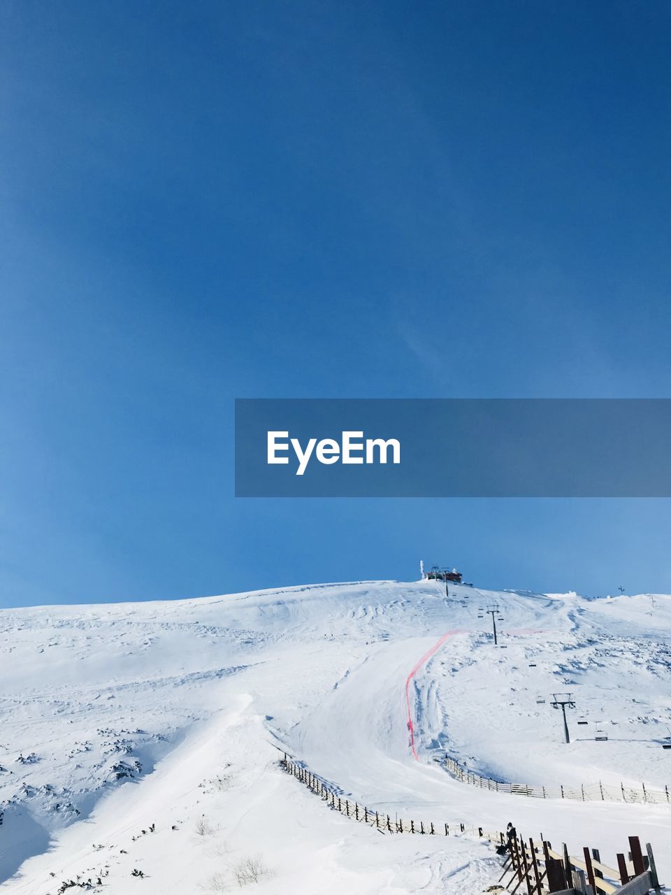 Aerial view of snowcapped mountain against blue sky