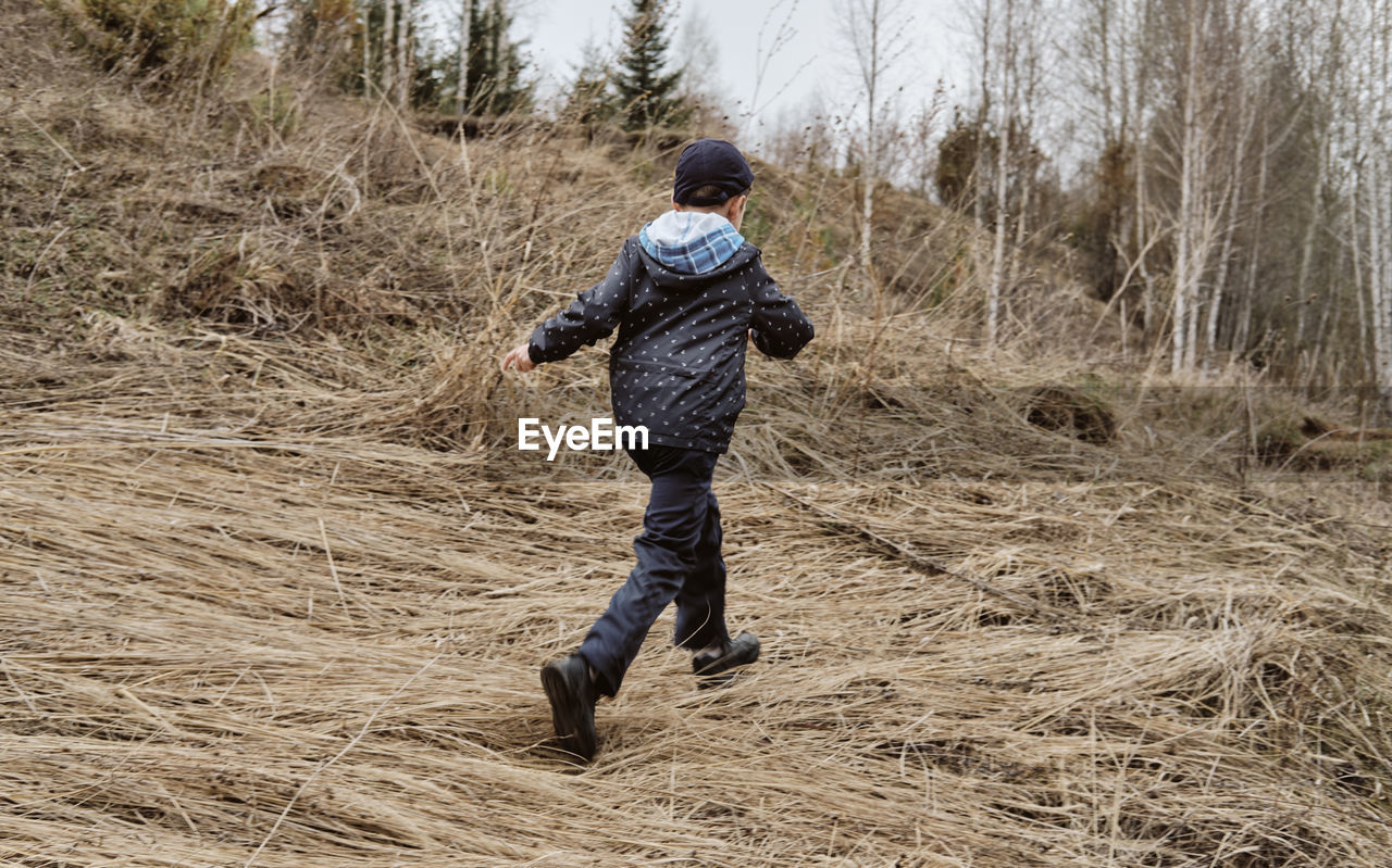 The boy runs across the field. minimalistic landscape with a running child