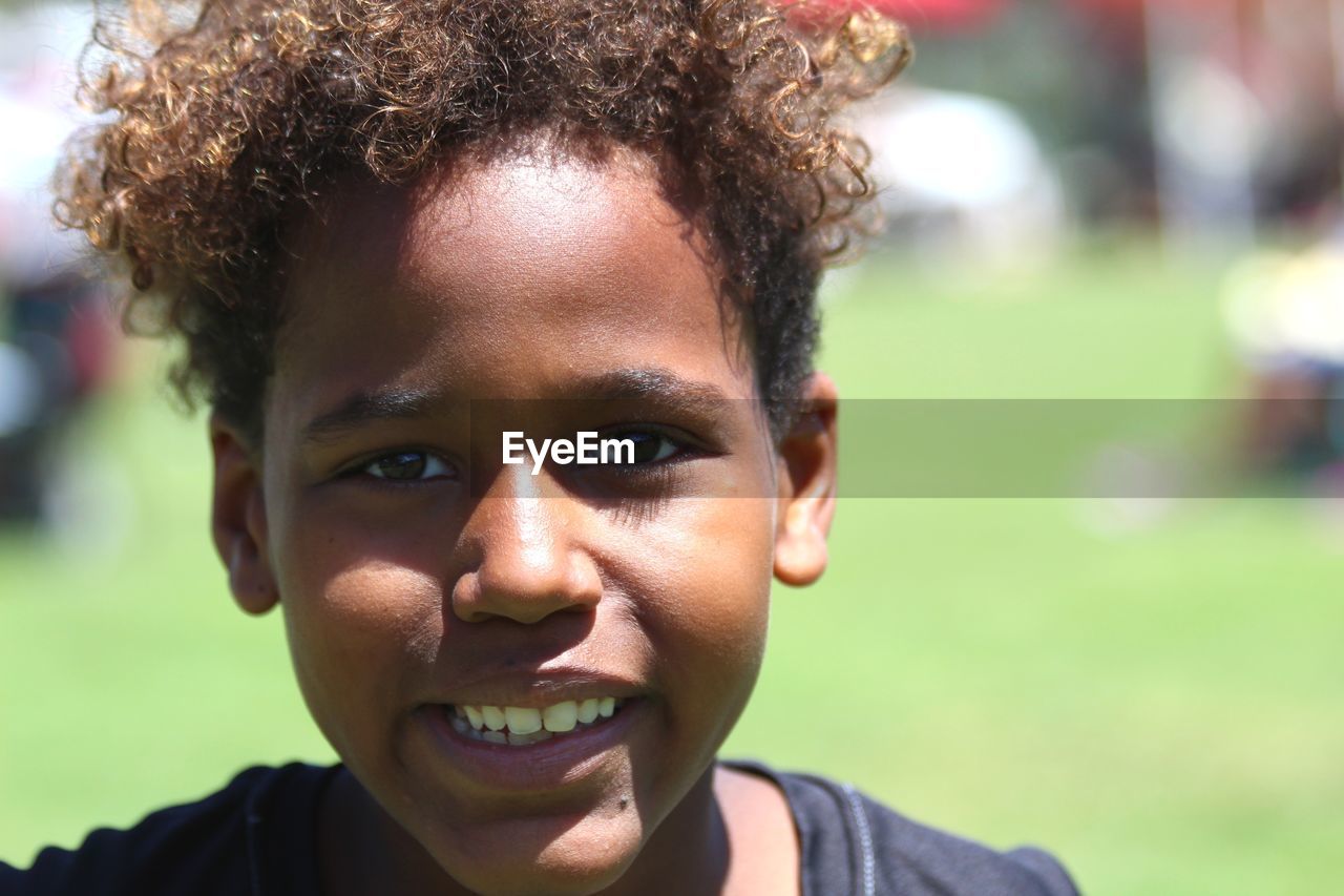 Portrait of smiling boy in park during sunny day