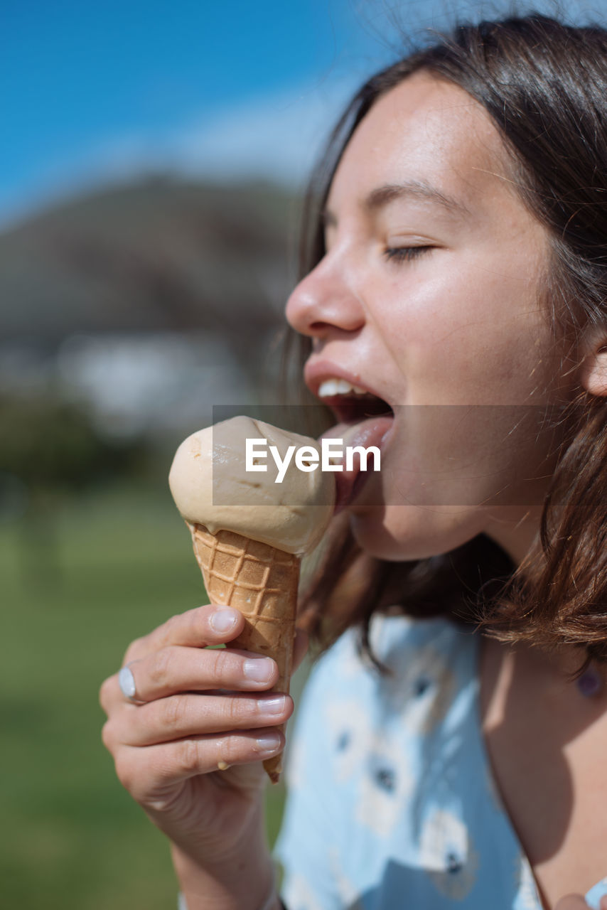 Young woman eating ice cream during summer