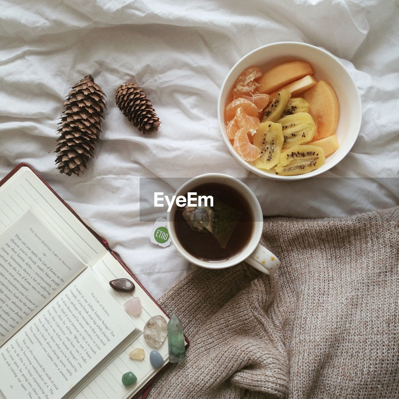 High angle view of drink with fruits and books on bed