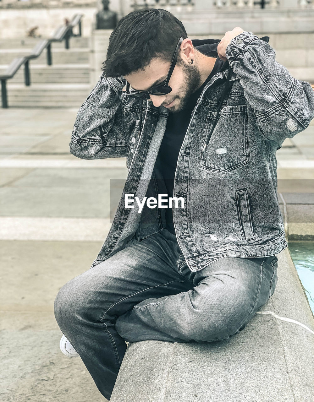 YOUNG MAN LOOKING AT CAMERA OUTDOORS