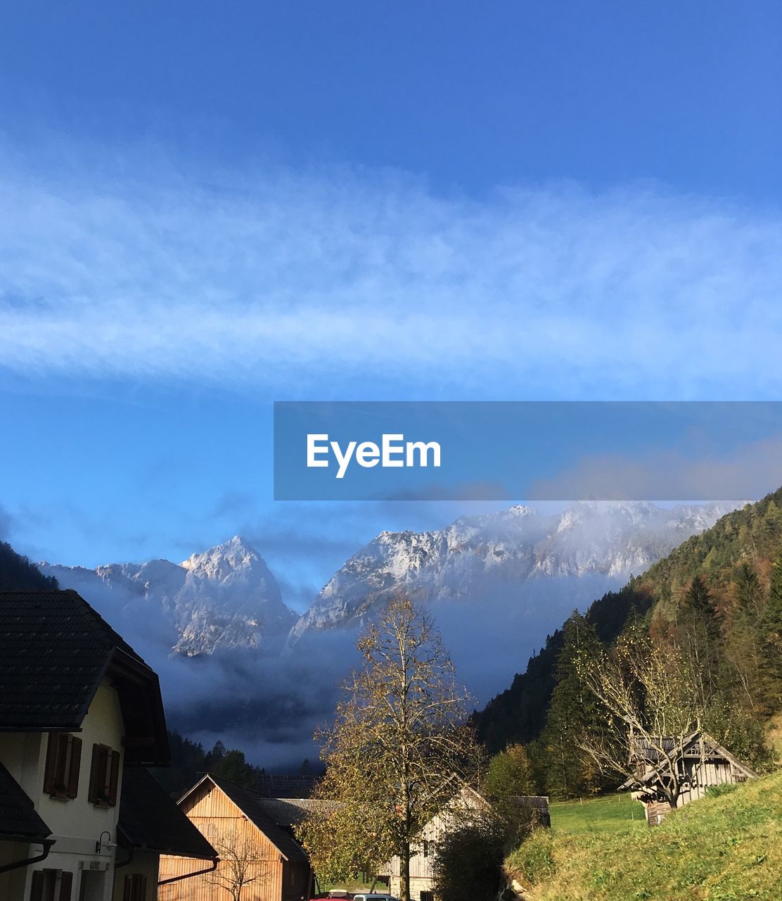 PANORAMIC VIEW OF HOUSES AND MOUNTAINS AGAINST SKY