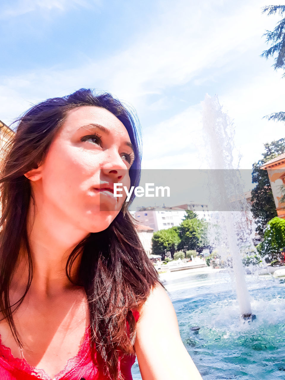 PORTRAIT OF BEAUTIFUL WOMAN IN SWIMMING POOL AGAINST SKY