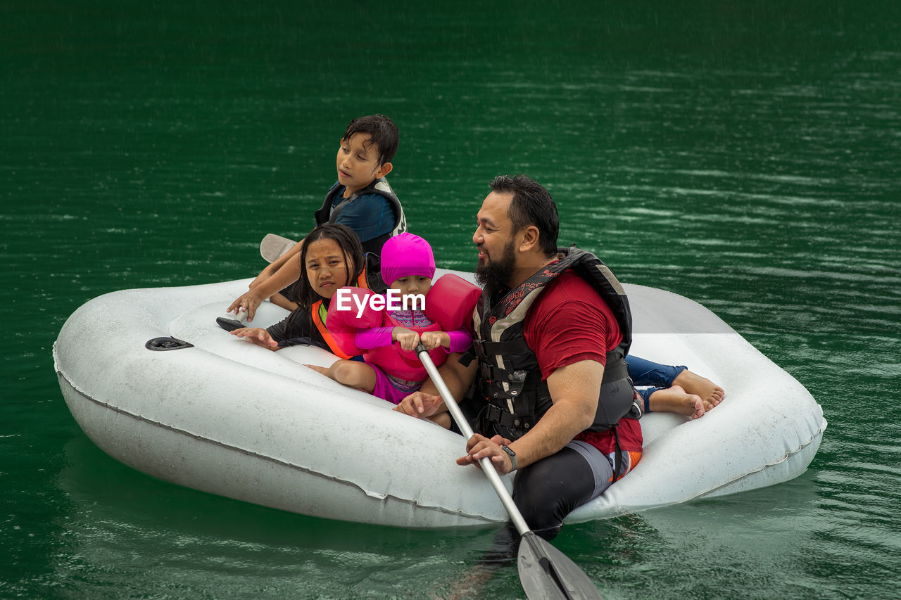 High angle view of family sitting in inflatable raft