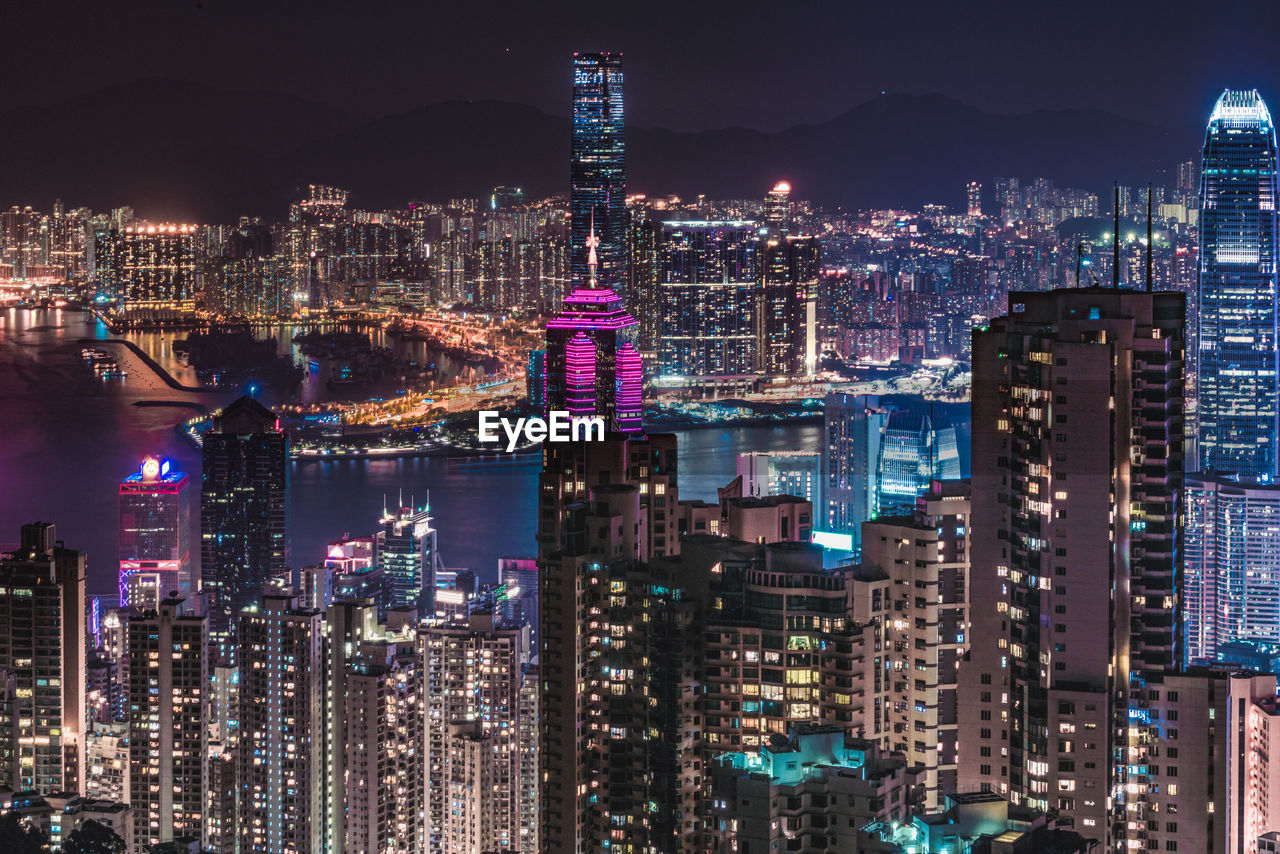 Illuminated cityscape against sky at night