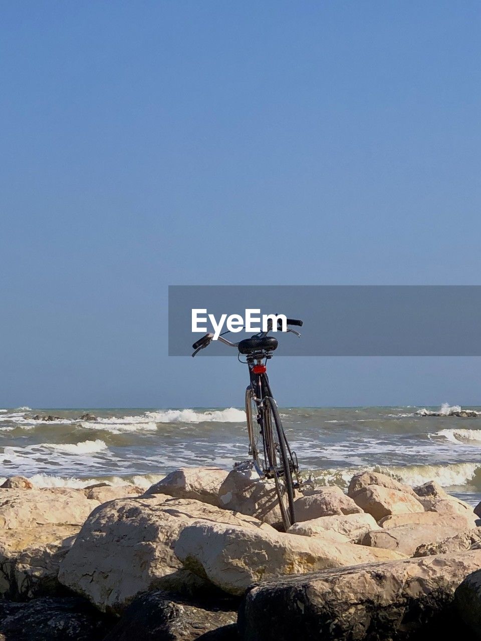 water, bicycle, sky, sea, vehicle, land, beach, nature, clear sky, coast, transportation, rock, copy space, horizon, day, horizon over water, sports, mode of transportation, sports equipment, sunny, mountain bike, ocean, motion, scenics - nature, sunlight, blue, travel, land vehicle, beauty in nature, outdoors, no people, activity, travel destinations, tranquility, extreme sports