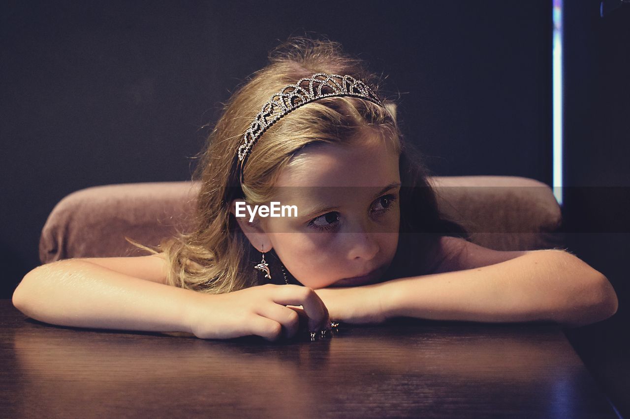 Close-up of girl sitting by table at home