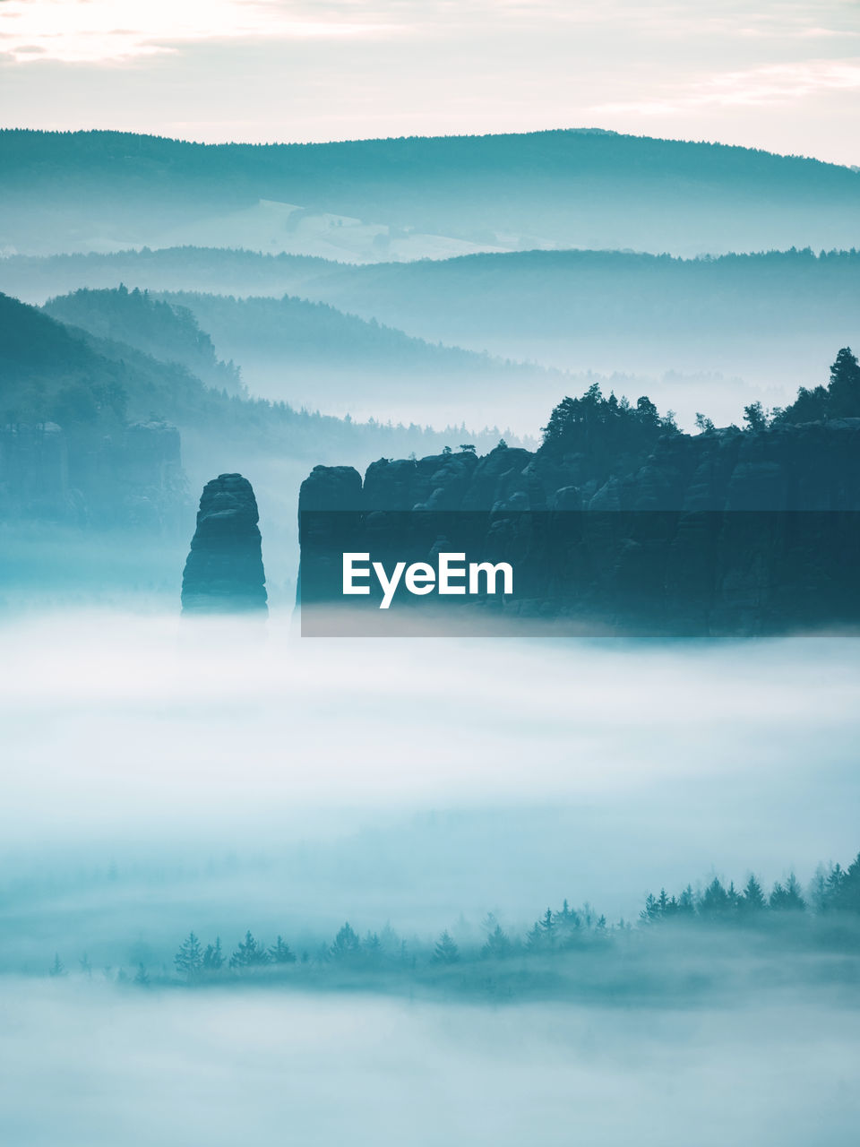 Mountain peak outline in blue night mist. row of foggy mountain ranges in sachsen deutschland park.