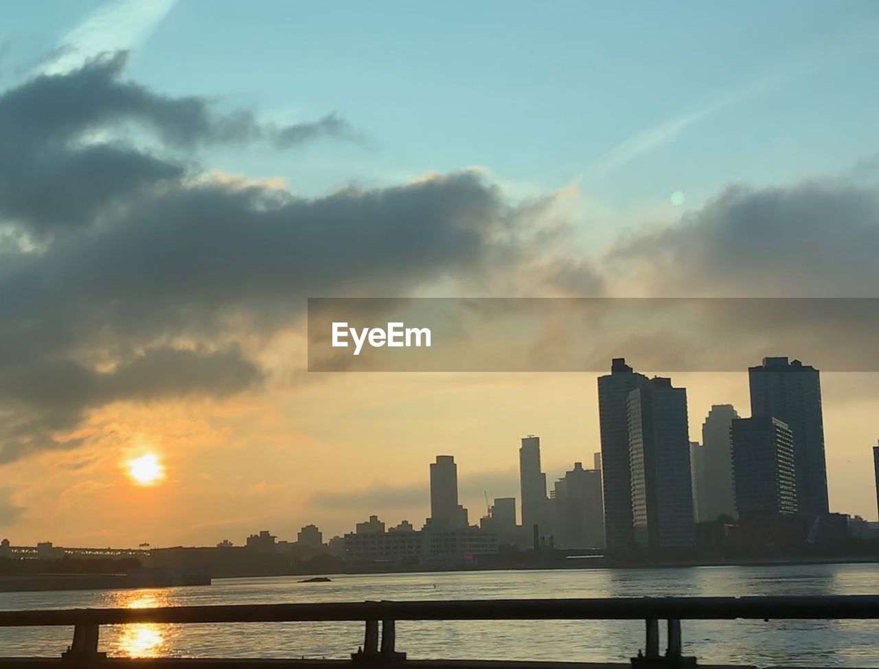 RIVER AND BUILDINGS AGAINST SKY DURING SUNSET