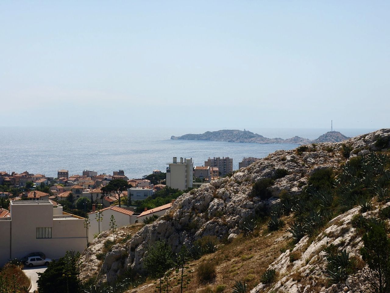 HIGH ANGLE VIEW OF SEA AND CITYSCAPE AGAINST SKY