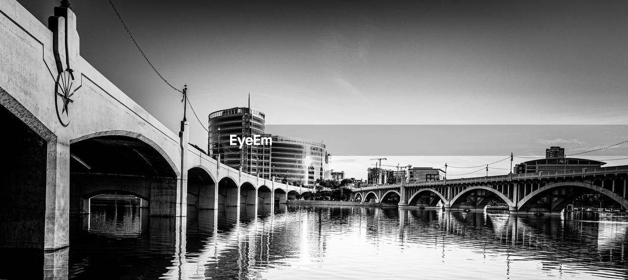 architecture, built structure, water, bridge, black and white, monochrome, sky, building exterior, reflection, cityscape, transportation, arch, monochrome photography, city, nature, travel destinations, river, no people, building, arch bridge, travel, nautical vessel, mode of transportation, outdoors, waterfront, waterway, tourism, day, black