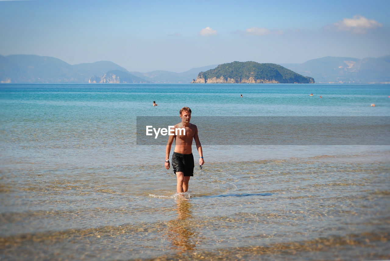 Man standing in sea against sky