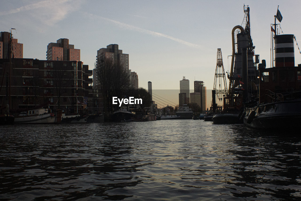 River amidst buildings in city against sky