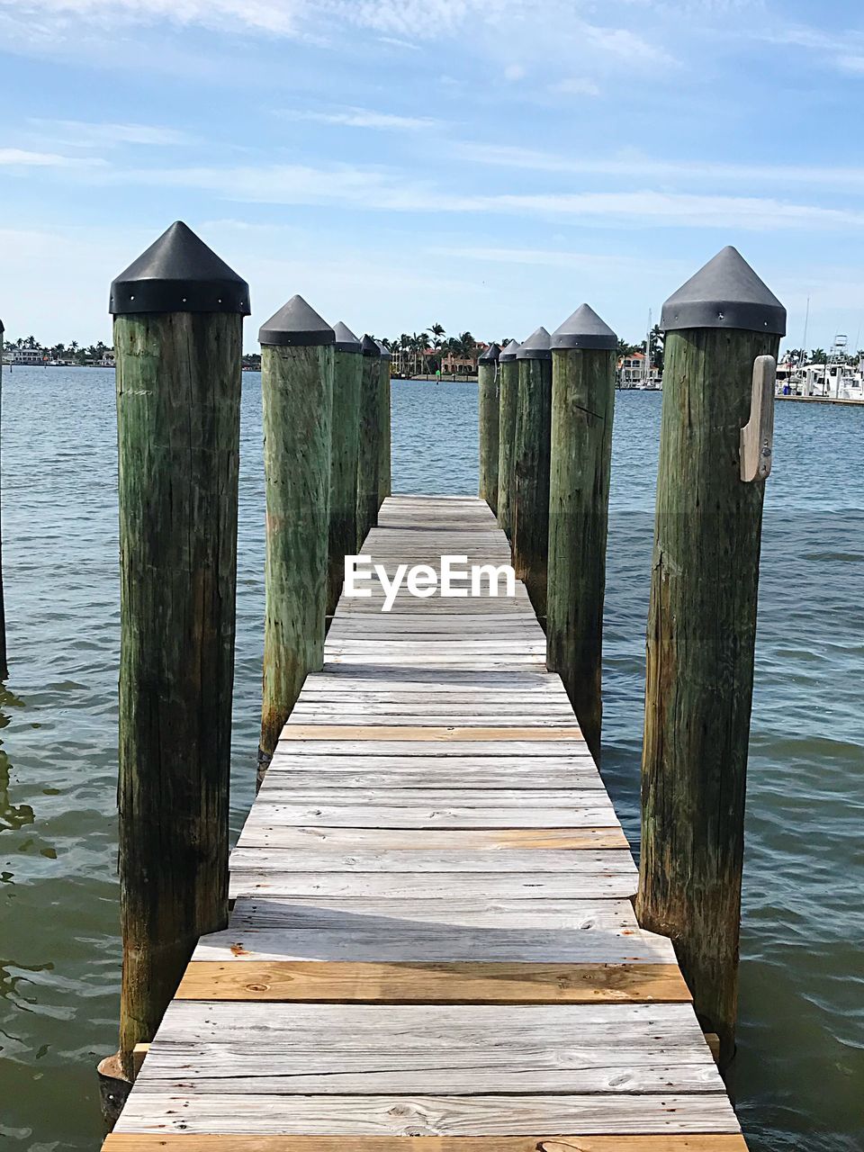 Wooden pier over sea against sky