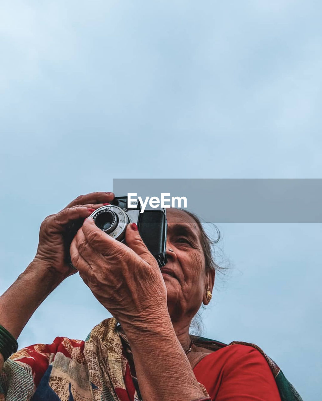 LOW ANGLE VIEW OF WOMAN PHOTOGRAPHING