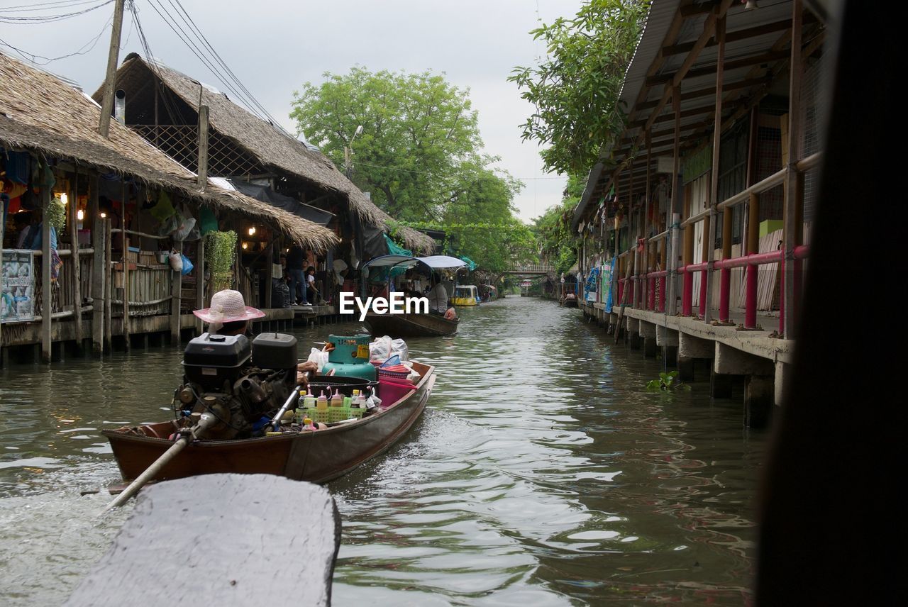 PEOPLE ON CANAL ALONG BUILDINGS