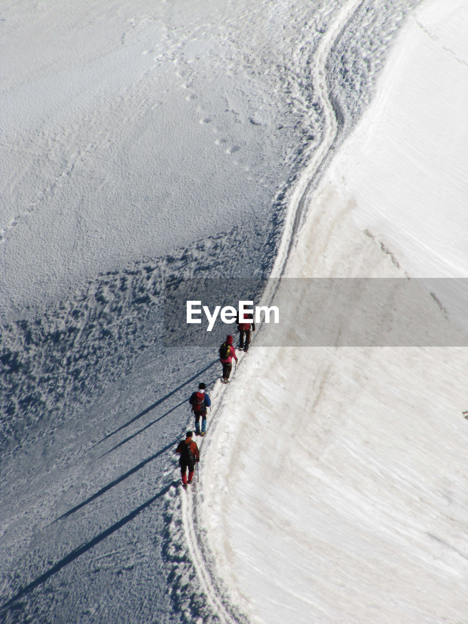 High angle view of people walking in snow covered landscape