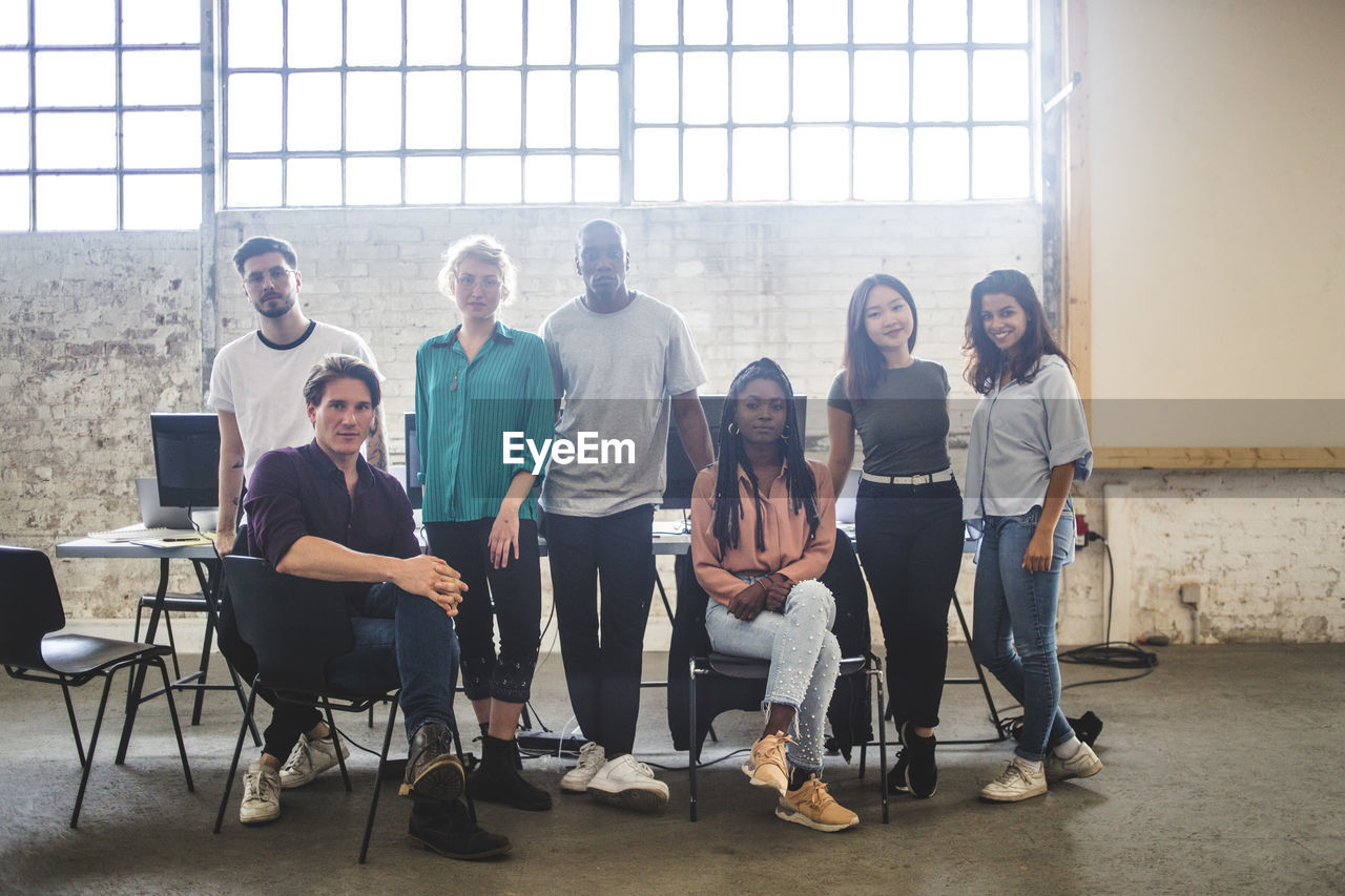 Portrait of confident young programmer's team at creative office