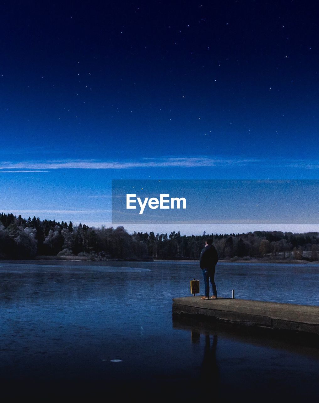 SILHOUETTE MAN STANDING BY LAKE AGAINST SKY AT NIGHT