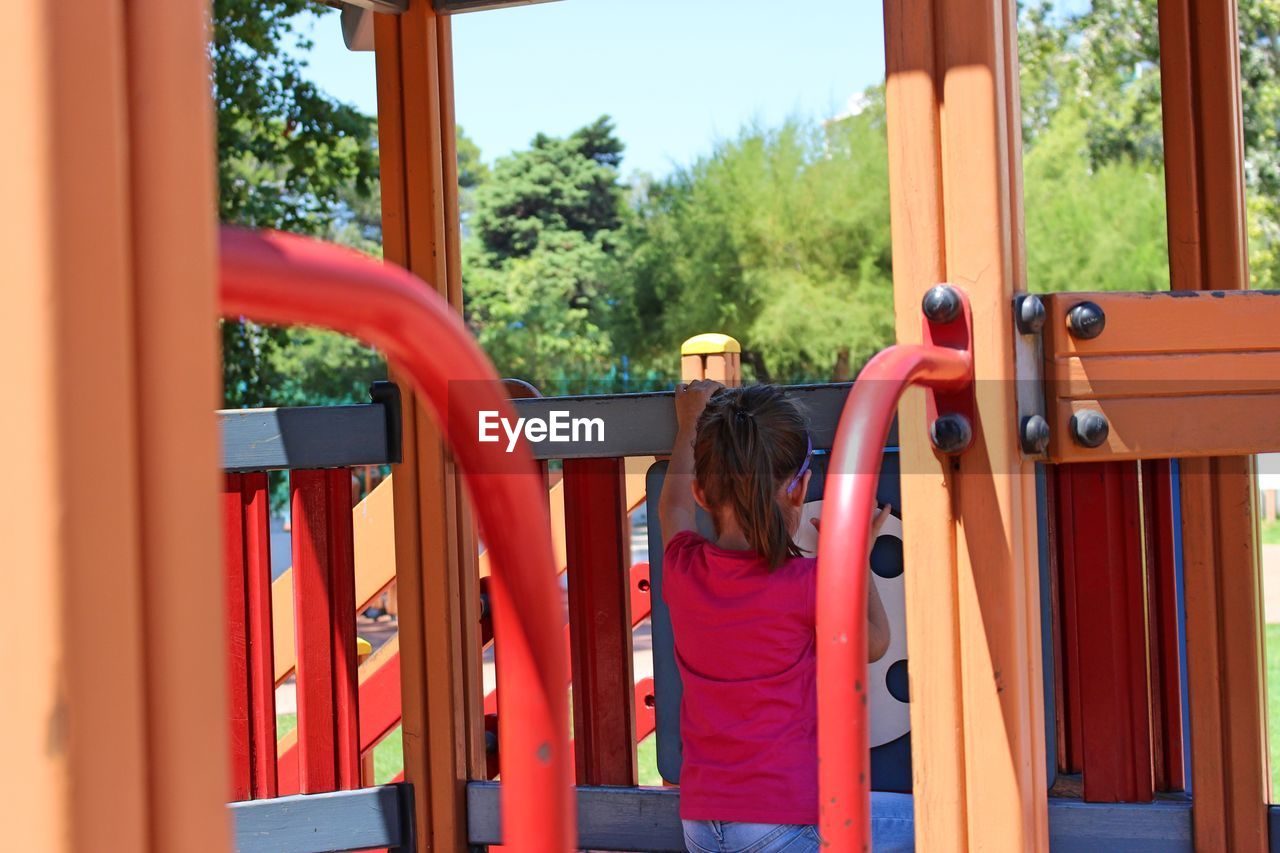 Rear view of girl playing on jungle gym