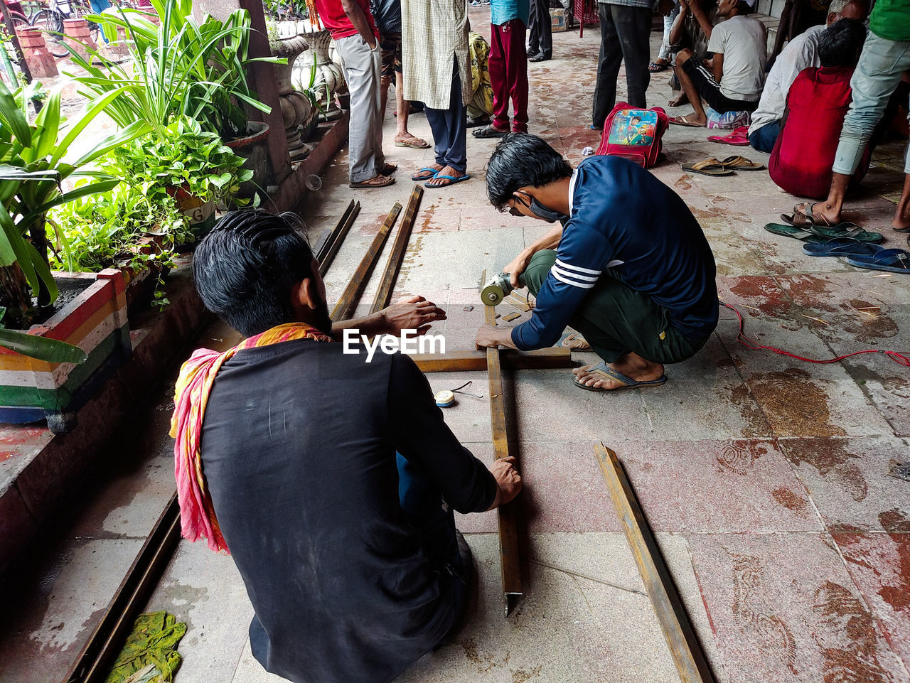 REAR VIEW OF PEOPLE SITTING ON TEMPLE