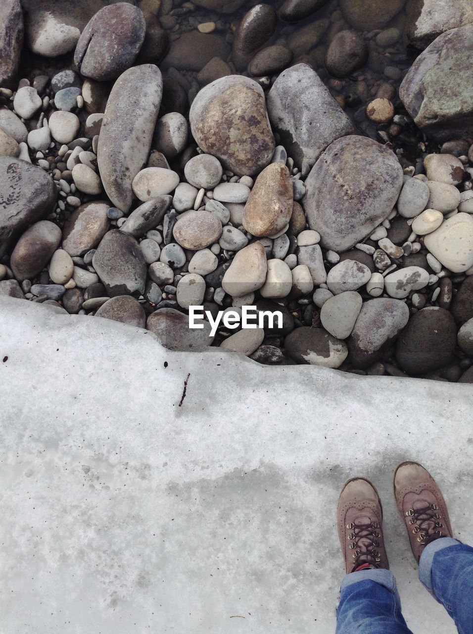 Low section of person standing on frozen lake