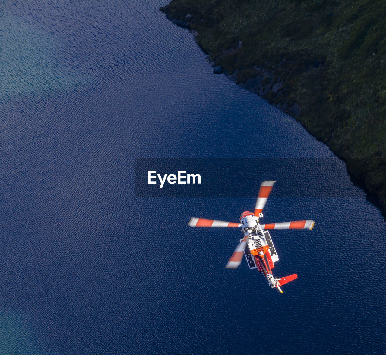 High angle view of helicopter flying over lake