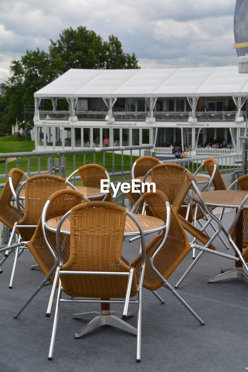 Empty chairs and tables at sidewalk cafe