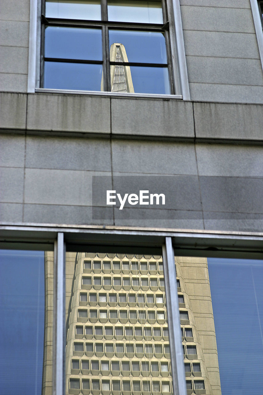 Low angle view of transamerica pyramid reflecting on glass