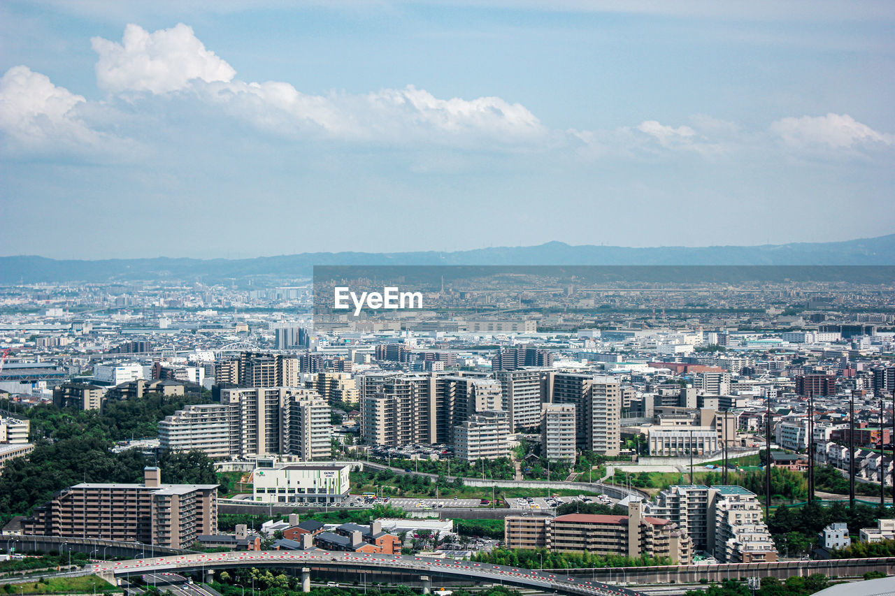 Aerial view of buildings in city against sky