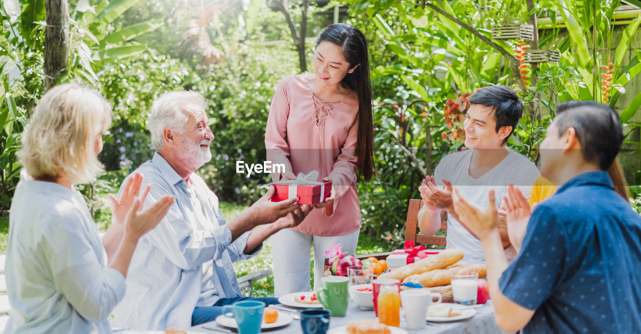 Cheerful family enjoying meal while sitting outdoors