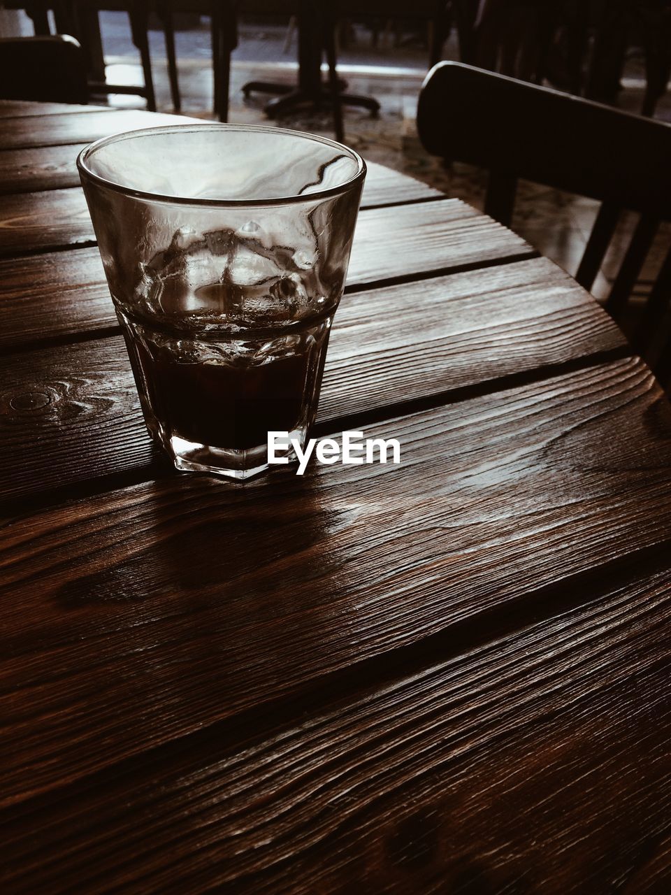 Partially empty glass on wooden bar table