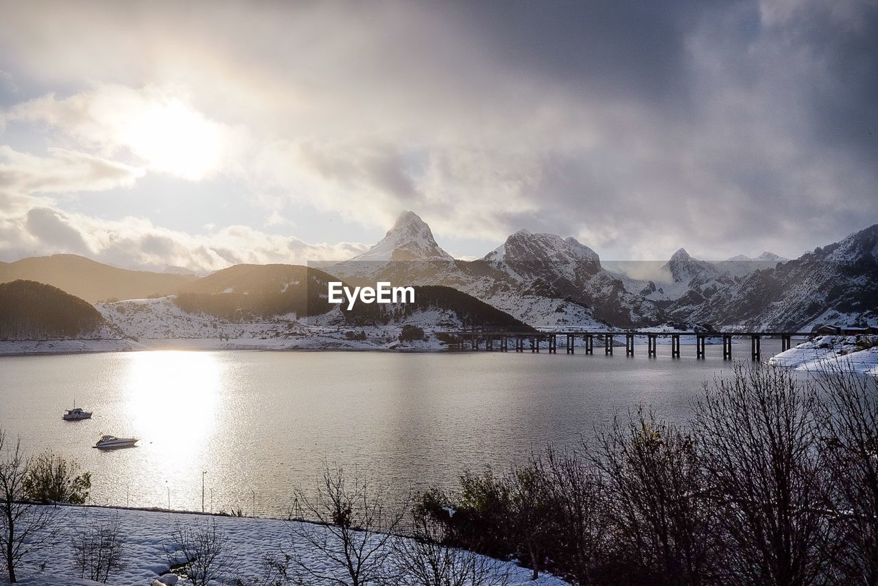 Scenic view of lake and snowcapped mountains against sky