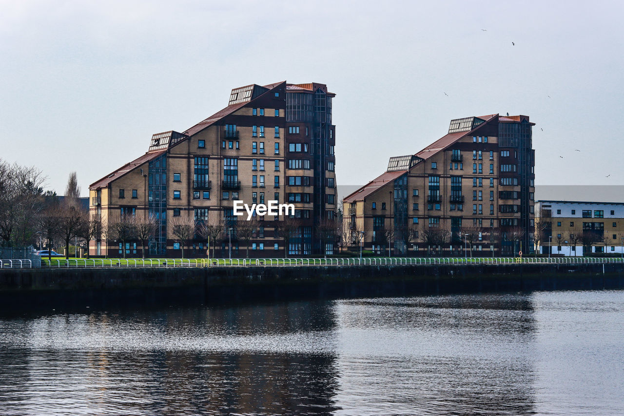 architecture, water, built structure, building exterior, reflection, waterway, cityscape, urban area, river, building, city, sky, skyline, nature, waterfront, no people, harbor, downtown, travel destinations, outdoors, day, tree, residential district, body of water, house, town, industry