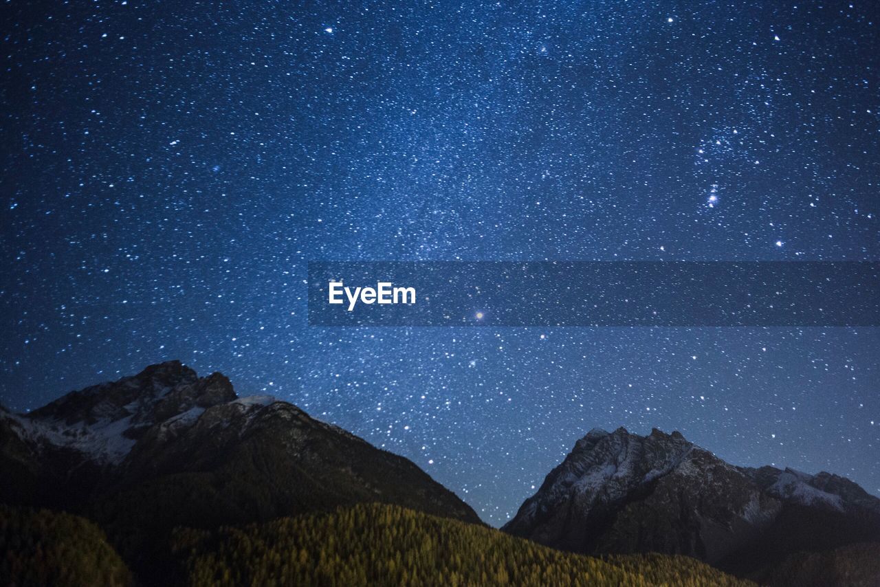 Scenic view of mountain against star field at night