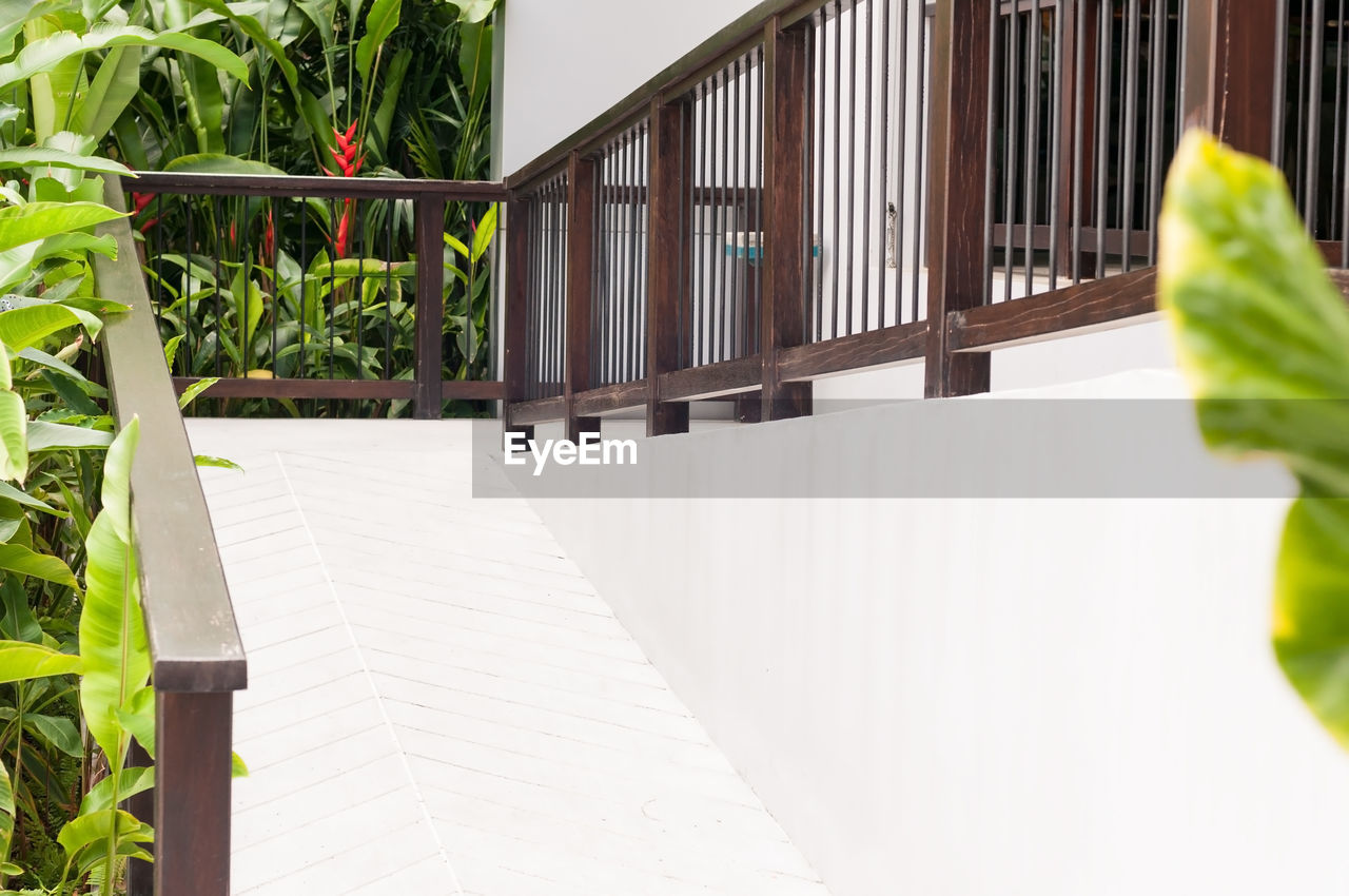 CLOSE-UP OF WHITE RAILING BY HOUSE