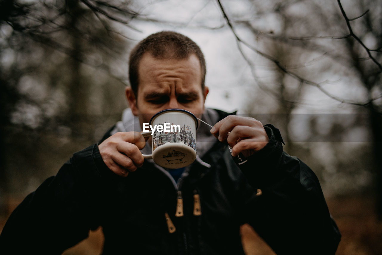 Man drinking coffee in forest