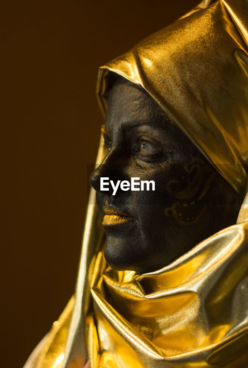 Portrait of a woman with black and gold make up, close up