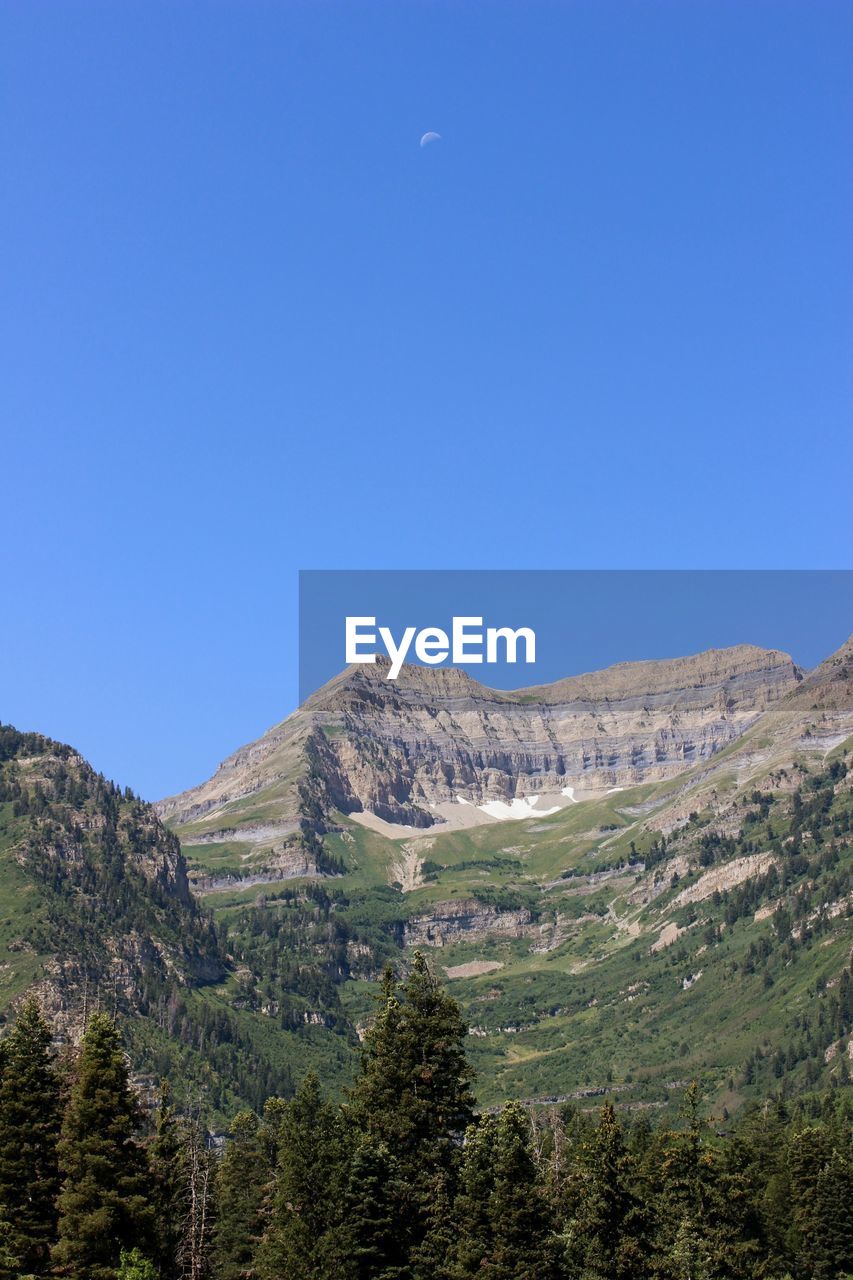 Scenic view of mountains against clear blue sky