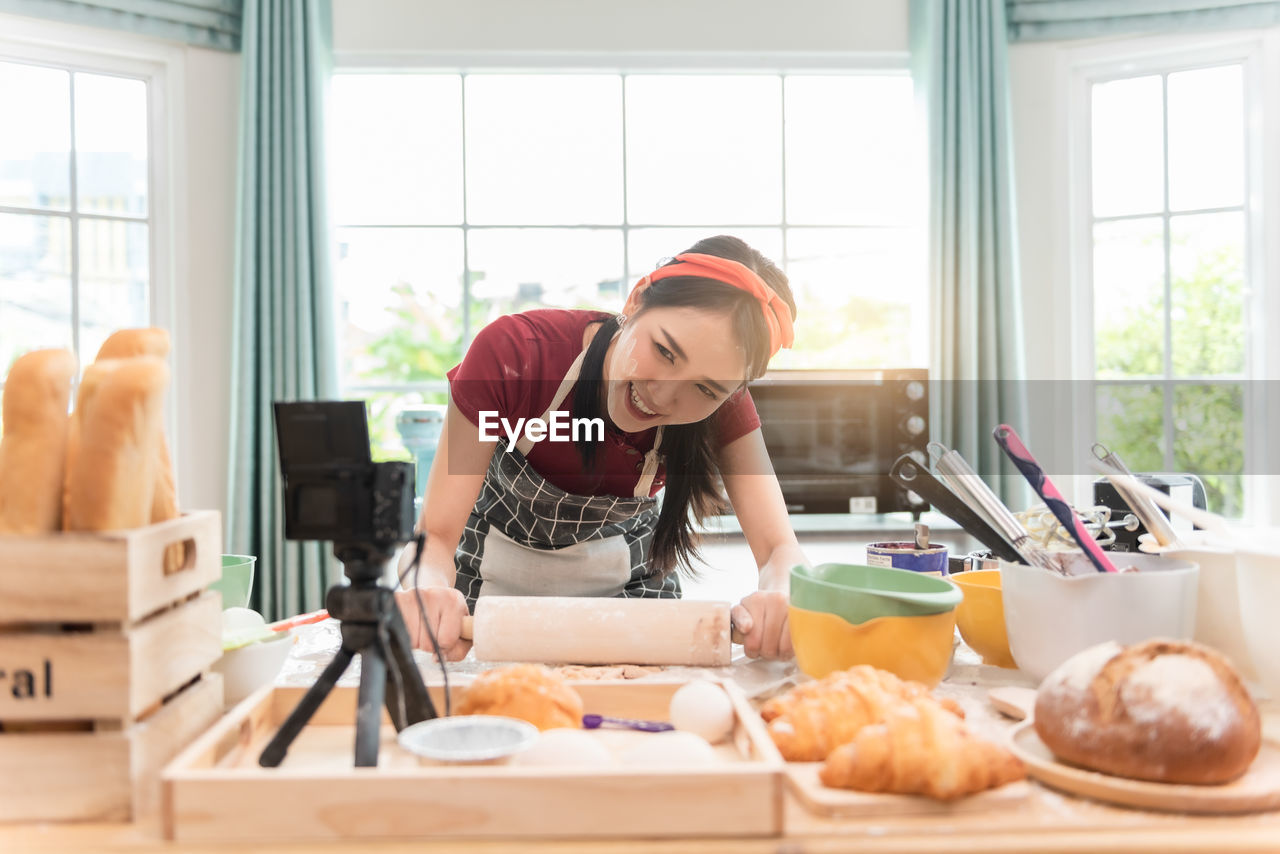 Cheerful chef preparing dessert while blogging