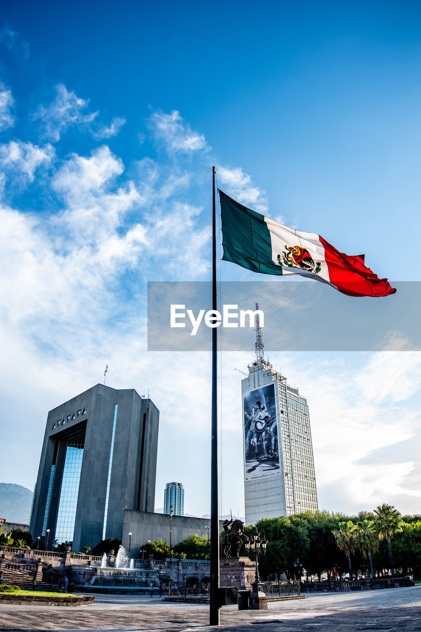 LOW ANGLE VIEW OF FLAG AGAINST BUILDINGS