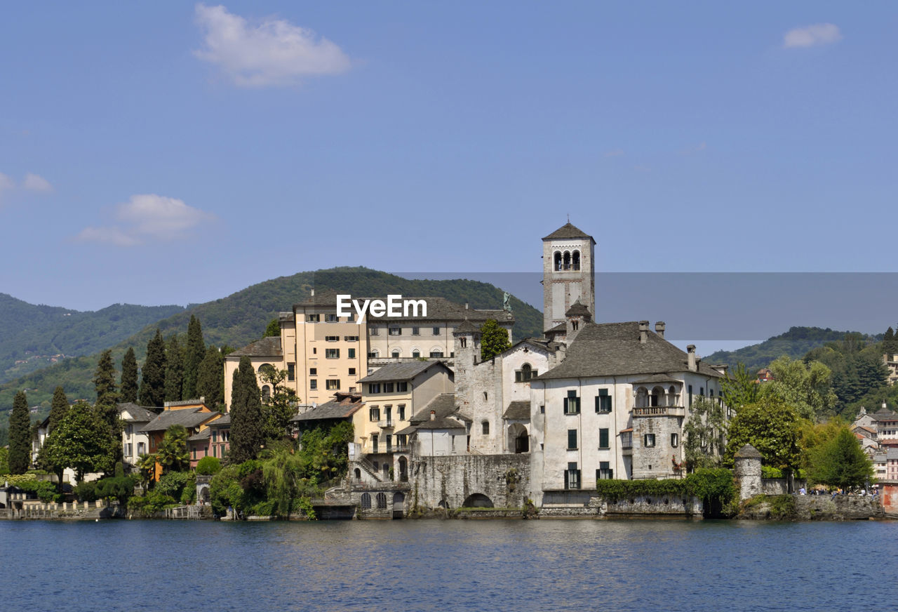 Buildings by mountains against sky