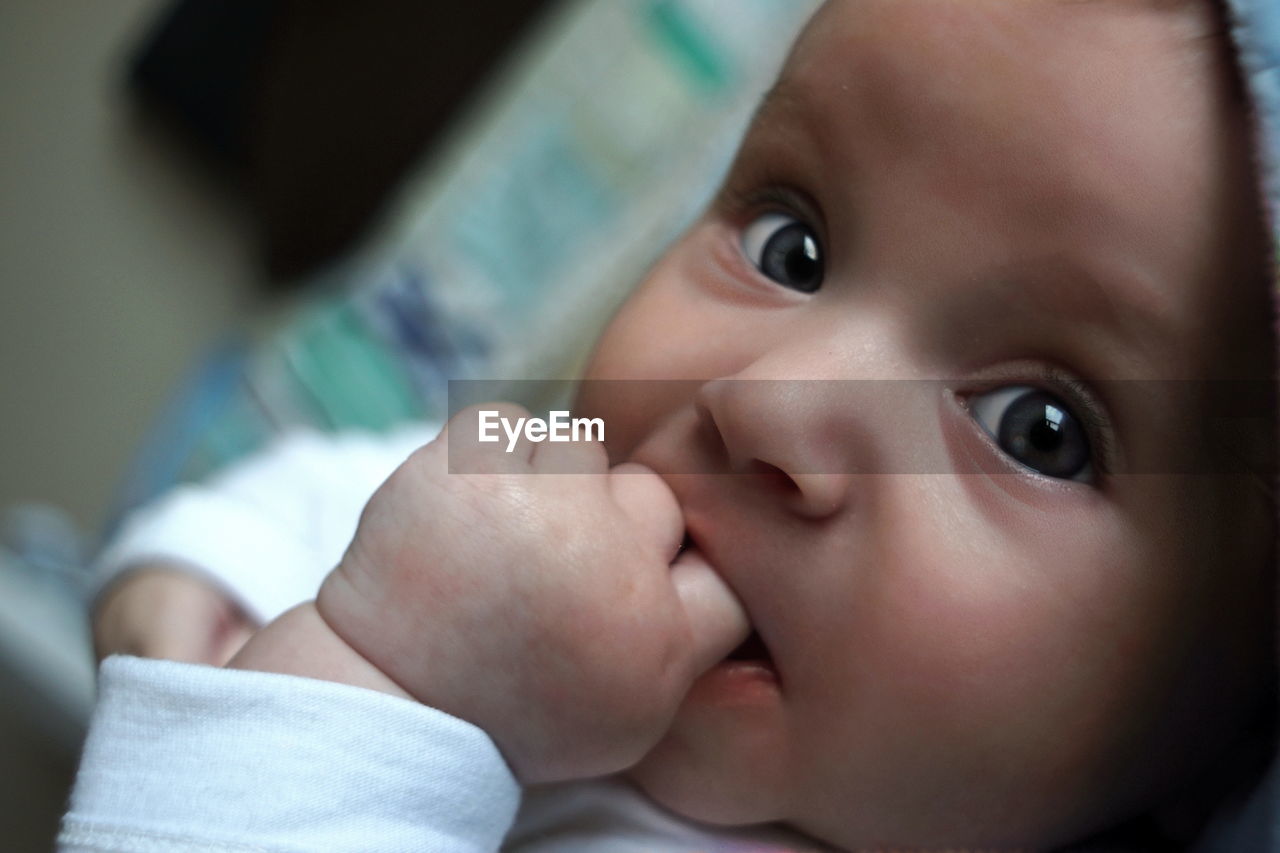 Close-up portrait of cute baby lying on bed